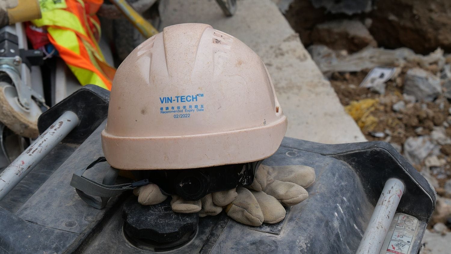 Casco de seguridad blanco y guantes de trabajo en obra, elementos de proteccion personal