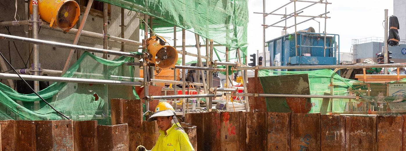 Operario con casco y ropa de alta visibilidad trabajando en obra bajo normas de higiene y seguridad