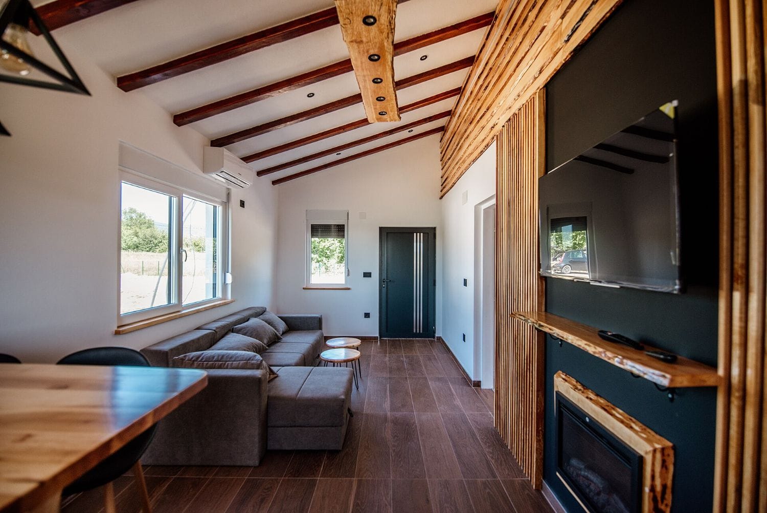 Living moderno con un gran sofa esquinero gris tapizado, ejemplo del tipo de sofas a medida que fabrica Diwan Interiorismo